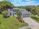 An aerial view of a landscaped single-Gathering home featuring mature trees and solar panels at 1631 Woodbay Ct, Kissimmee, FL 34744