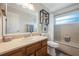 Well-lit bathroom features a vanity with sink, decorative shelving and shower-tub combo at 1631 Woodbay Ct, Kissimmee, FL 34744