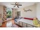 Bright bedroom with large arched window, floral curtains, ceiling fan, and hardwood flooring at 1631 Woodbay Ct, Kissimmee, FL 34744