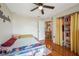 Cozy bedroom with a ceiling fan, hardwood floors and closet area with bright yellow curtain at 1631 Woodbay Ct, Kissimmee, FL 34744