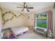 Charming bedroom with a large window, natural light, plush carpet, and decorative wall accents at 1631 Woodbay Ct, Kissimmee, FL 34744