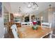 Light and airy dining room features stylish lighting and a rustic wooden table with white chairs at 1631 Woodbay Ct, Kissimmee, FL 34744