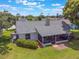 Back exterior view featuring mature landscaping and screened-in lanai, enhancing outdoor living space at 1631 Woodbay Ct, Kissimmee, FL 34744