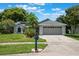 Charming single-story home features a well-maintained lawn, beautiful landscaping, and a two-car garage at 1631 Woodbay Ct, Kissimmee, FL 34744