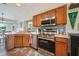 Well-equipped kitchen with stainless steel appliances and wood cabinetry with decorative backsplash at 1631 Woodbay Ct, Kissimmee, FL 34744