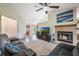Cozy living room features a ceiling fan, fireplace, plush seating and seamless access to dining area at 1631 Woodbay Ct, Kissimmee, FL 34744