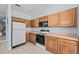 Bright kitchen with white tile flooring, wood cabinets, and an electric range at 1760 Saint Tropez Ct, Kissimmee, FL 34744