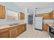 Well-lit kitchen features tile floor, wood cabinets, and neutral countertops at 1760 Saint Tropez Ct, Kissimmee, FL 34744