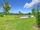 Enjoy the idyllic backyard view complete with pond, lawn, landscaping, and blue skies at 1870 Brentwood Ct, Davenport, FL 33837