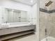 Bright bathroom with double sink, gray cabinets, large mirror, and walk-in shower at 1870 Brentwood Ct, Davenport, FL 33837
