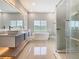 Bright bathroom features a soaking tub, dual vanities, and glass shower at 1870 Brentwood Ct, Davenport, FL 33837