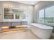 Stylish bathroom with a double sink vanity, large mirror with lighting, a soaking tub and a view at 1870 Brentwood Ct, Davenport, FL 33837