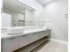 Bright bathroom with a double sink vanity, sleek gray cabinets, and a large mirror at 1870 Brentwood Ct, Davenport, FL 33837