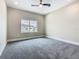 A bedroom with neutral walls, plush carpet, and a window providing natural light at 1870 Brentwood Ct, Davenport, FL 33837