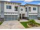Modern townhouses featuring a two-car garage, balcony, and decorative stone accents at 1870 Brentwood Ct, Davenport, FL 33837