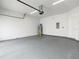 Spacious garage with overhead lighting, hot water tank, and painted concrete floors at 1870 Brentwood Ct, Davenport, FL 33837