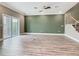 Spacious living room with sliding glass doors, a staircase, and wood-look flooring at 1870 Brentwood Ct, Davenport, FL 33837