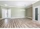 Spacious open living room with modern light fixture, wood-look flooring, and large doors at 1870 Brentwood Ct, Davenport, FL 33837