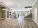Open floor plan featuring modern stainless appliances and wood look floor with staircase at 1870 Brentwood Ct, Davenport, FL 33837