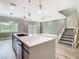 Kitchen island with a view of the living area and staircase with metal cable railing at 1870 Brentwood Ct, Davenport, FL 33837