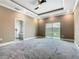 Spacious primary bedroom with large windows, tray ceiling, fan, carpet, and ensuite bathroom at 1870 Brentwood Ct, Davenport, FL 33837