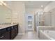 Bright bathroom featuring a glass shower, soaking tub, double vanity, and exterior access to the pool area at 2176 Lelani Cir, Davenport, FL 33897
