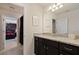 Clean bathroom with granite countertops, dark wood cabinets, and neutral tile flooring at 2176 Lelani Cir, Davenport, FL 33897