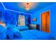 Themed bedroom with twin beds, decorative accents, and a wall-mounted TV for a fun and relaxing space at 2176 Lelani Cir, Davenport, FL 33897