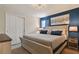 Bedroom features a large bed, wood furniture, and blue accent wall with art and blue striped curtains at 2176 Lelani Cir, Davenport, FL 33897