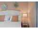 Bright bedroom with decorative flower accents, side table and decorative 'Be Kind' pillows on bed at 2176 Lelani Cir, Davenport, FL 33897