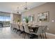 Spacious dining room with seating for twelve, decorative mirrors, modern lighting, and access to an outdoor patio at 2176 Lelani Cir, Davenport, FL 33897