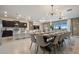 Bright dining area featuring a large table set for twelve, modern lighting, and an open-concept design with a view of the kitchen at 2176 Lelani Cir, Davenport, FL 33897