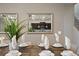 Close-up view of a beautifully set dining table, featuring modern decor, neutral tones, and a glimpse of the kitchen at 2176 Lelani Cir, Davenport, FL 33897