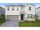 Charming two-story home featuring a two-car garage, well-maintained lawn, and welcoming front entrance at 2176 Lelani Cir, Davenport, FL 33897
