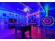 Fun game room with foosball table, custom mural, and neon lighting for an entertaining atmosphere at 2176 Lelani Cir, Davenport, FL 33897