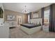 Comfortable main bedroom with modern chandelier, neutral walls, and large windows with decorative curtains at 2176 Lelani Cir, Davenport, FL 33897