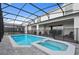 A luxurious backyard with a screened-in pool, spa, and patio area, designed for relaxation and entertaining at 2176 Lelani Cir, Davenport, FL 33897