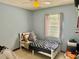 This bedroom features a twin bed with a patterned bedspread and light-blue walls at 2266 Lake Lizzie Ct, St Cloud, FL 34771