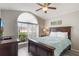 Comfortable bedroom with a large window, hardwood furniture, light gray walls, and a ceiling fan at 2685 Oneida Loop, Kissimmee, FL 34747
