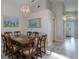 Dining room with a chandelier, wooden dining table, and a view of the hallway at 2685 Oneida Loop, Kissimmee, FL 34747