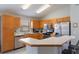Traditional style kitchen with stainless steel appliances, wood cabinets, and breakfast bar at 2685 Oneida Loop, Kissimmee, FL 34747