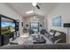 Bright living room featuring vaulted ceilings, ceiling fans, and access to outdoor patio at 2685 Oneida Loop, Kissimmee, FL 34747