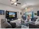 Comfortable living room features a large television, ceiling fans, gray sofas, and glass table at 2685 Oneida Loop, Kissimmee, FL 34747