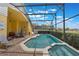 Relaxing screened-in pool area features a hot tub, brick patio, and a lush backyard landscape at 2685 Oneida Loop, Kissimmee, FL 34747