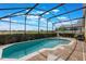 Screen-enclosed pool and patio area with lounge chairs, a grill, and clear views of the horizon at 2685 Oneida Loop, Kissimmee, FL 34747