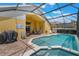 Screen-enclosed pool area features a hot tub, patio seating, and brick-paved deck at 2685 Oneida Loop, Kissimmee, FL 34747
