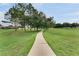 Scenic walking path surrounded by lush green grass and mature trees, perfect for a leisurely stroll at 2685 Oneida Loop, Kissimmee, FL 34747