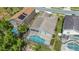 Aerial view of the property showcases a screened-in pool and lush surroundings in a desirable community at 307 Balmoral Ct, Davenport, FL 33896