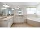 Bathroom featuring double sinks, vanity, soaking tub, and tile flooring at 307 Balmoral Ct, Davenport, FL 33896
