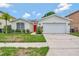 Charming one-story home with well-maintained lawn and a bright red front door, plus a two car garage at 307 Balmoral Ct, Davenport, FL 33896